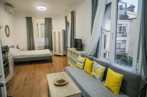 a living room with a couch and a large window at Casa San Roque in Seville