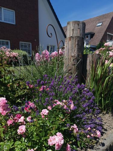 a garden of flowers in front of a house at Hotel-Pension Achtern Diek in Büsum