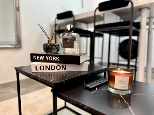- une table avec une bouteille de nouveau york et une bougie dans l'établissement Résidence Auguste Comte - avec Balcon - Cœur de Dijon, à Dijon