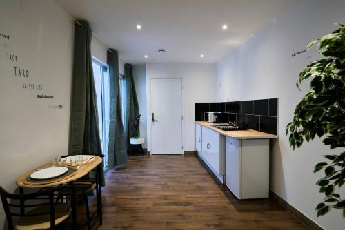 une cuisine avec une table, des chaises et un comptoir dans l'établissement NG Prestige - Balnéo - TV - Netflix - WIFI - Cour, à Roubaix