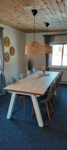 a large wooden table with chairs in a room at 'Bij de buren' in Norra Skoga
