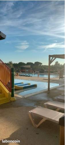 a playground with a pool and a bench on a beach at Mobil-Home Camping 6 personnes ARDECHE Le Domaine de Chaussy in Ruoms