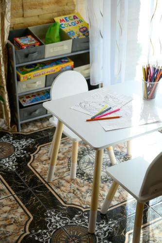 a white table and chairs with pencils on it at Pezsgő Vendégház in Demjén