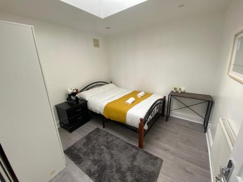 a small bedroom with a bed and a table at Cosy 2 Room Space Near Station in Mitcham