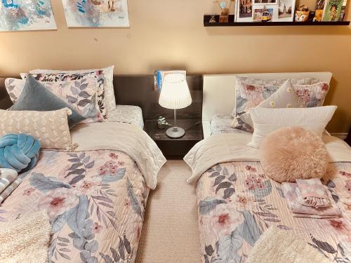 a bedroom with two beds and a table with a lamp at Scorpion Hiuse Langley -ROOM A in Langley