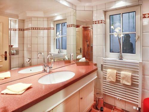 une salle de bain avec un lavabo et un grand miroir dans l'établissement Luxus Heefwai, à Morsum