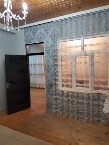 a room with a door and a window with curtains at Minimalist Escape in Sheki