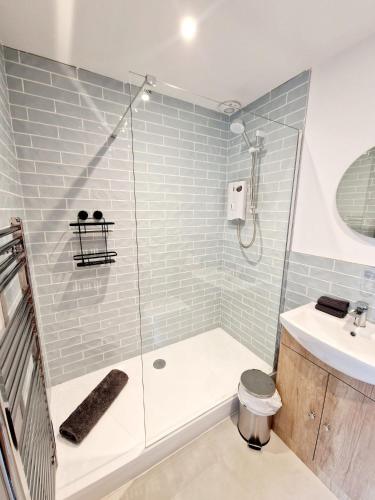 a bathroom with a shower and a toilet and a sink at The Old Bakehouse in Ulverston