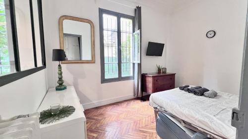 - une chambre avec un lit, un miroir et une commode dans l'établissement Le Palais Jean, à Nice