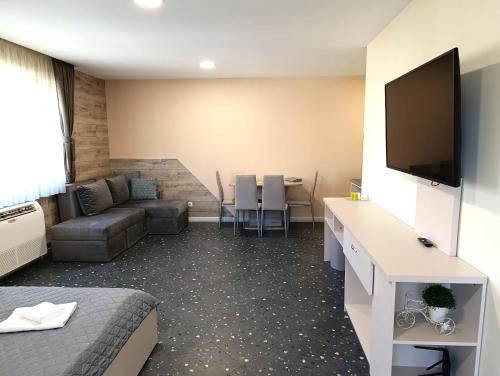 a room with a living room with a couch and a tv at Lime house in Kyustendil