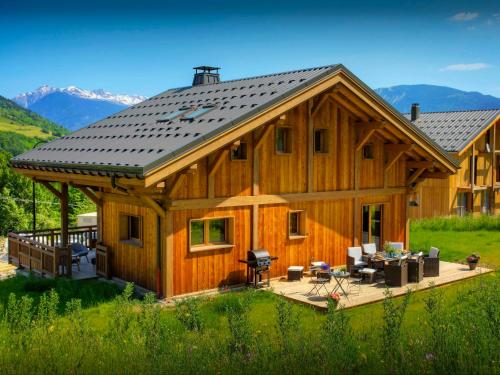 Cette grande maison en bois dispose d'une terrasse et d'un barbecue. dans l'établissement Chalet Pajules - OVO Network, à Le Fey