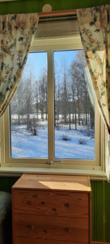a window with a view of a snow covered field at 'Bij de buren' in Norra Skoga