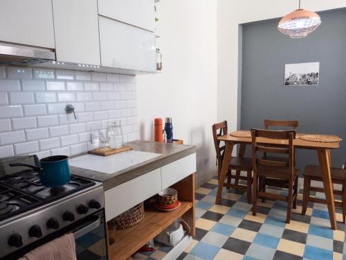 a kitchen with a stove and a table with chairs at Habitación privada, solo Damas "Alma de mujer" in Buenos Aires