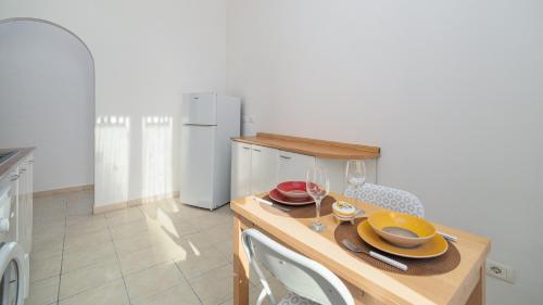 a kitchen with a table with plates and wine glasses at Don Leandro's House by Rentbeat in Civitavecchia