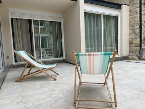 two chairs sitting on a patio in front of a house at Studio Les Hauteurs de Juziers in Juziers