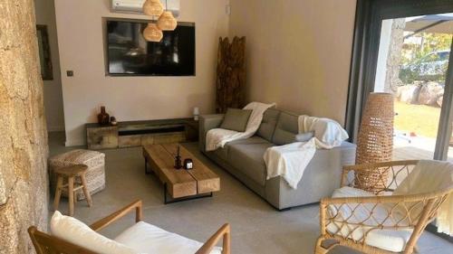 un salon avec un canapé et une table dans l'établissement Villa Isula Bella, 8 pers, piscine chauffée, proche plage, à Sainte-Lucie de Porto-Vecchio