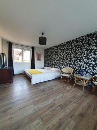 a bedroom with a large bed and a table at Grande maison proche Colmar in Niederhergheim