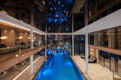 a hotel lobby with a blue pool in the middle at Wellness & Naturhotel Tonihof in Langdorf im Landkreis Regen