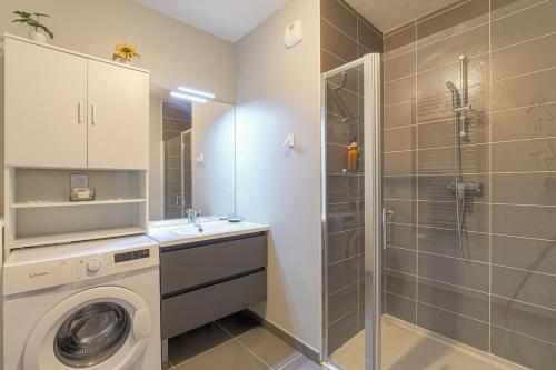 La salle de bains est pourvue d'un lave-linge et d'une douche. dans l'établissement Cocon urban Terrasse et Stationnement gratuit, à Villeurbanne