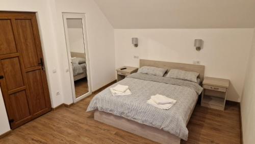 a bedroom with a bed with two towels on it at Pensiunea Deak Panzio in Sovata
