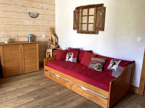 a living room with a couch with red cushions at Studio cosy à La Plagne-Tarentaise, 20 m² + vue sur montagne in La Plagne Tarentaise