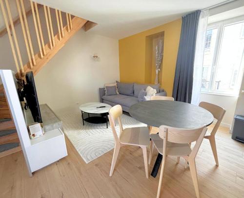 un salon avec une table et un canapé dans l'établissement Les Cascades, T2 duplex avec climatisation et balcon, à Lons-le-Saunier