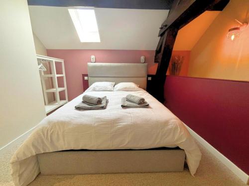 une chambre avec un lit avec deux serviettes dessus dans l'établissement Les Cascades, T2 duplex avec climatisation et balcon, à Lons-le-Saunier