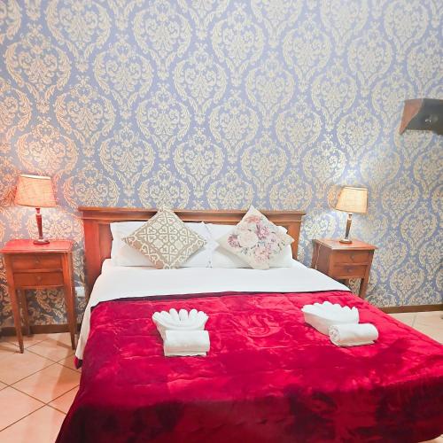 a bedroom with a red bed with two towels on it at Hotel Giubileo in Rome