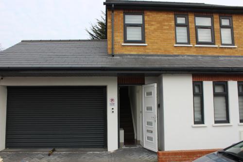a garage with a car parked in front of a house at Contemporary 2 bed house with Parking in West Thurrock