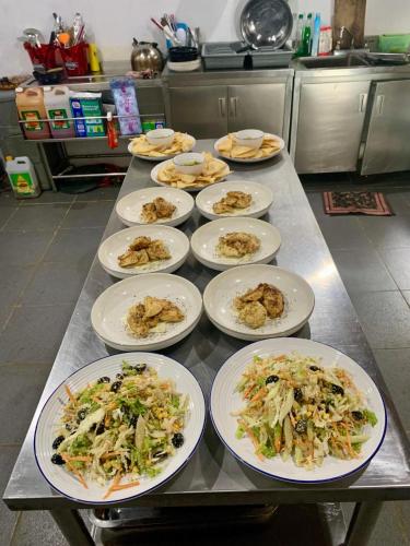 a table with white plates of food on it at Sunset Surfing Villas Mentawai in Tuapejat