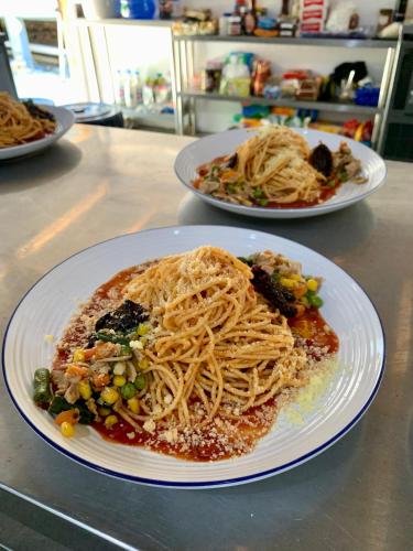 two plates of pasta and vegetables on a counter at Sunset Surfing Villas Mentawai in Tuapejat
