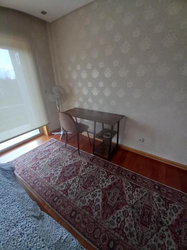 a bedroom with a table and a desk with a chair at Com o Douro à vista in Jovim