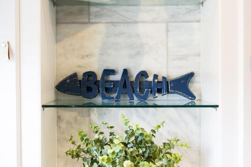 a glass shelf with a fish sign in a window at Church Hill House in Port Isaac