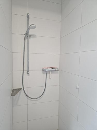 a shower in a bathroom with white tiles at Wohnung 2 in Haselünne