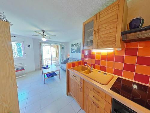 - une cuisine avec un évier et du carrelage orange sur le mur dans l'établissement Appartement 2 pièces cabine 5 couchages LA LONDE LES MAURES LAL100-117, à La Londe-les-Maures