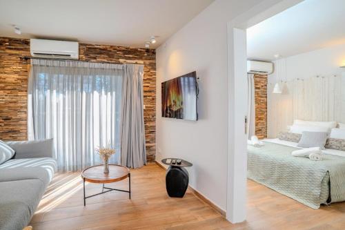 a bedroom with a bed and a couch in a room at Ein Zivan Village Resort in Ein Zivan