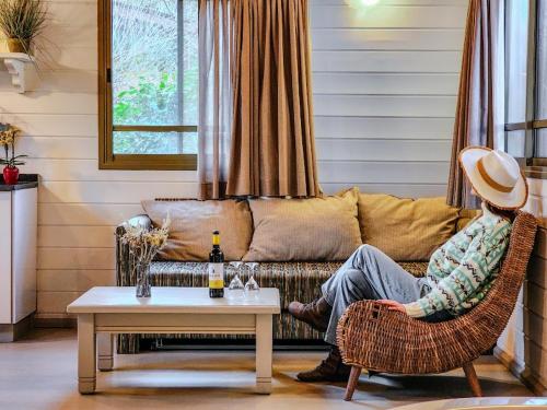 a person sitting on a couch in a living room at Ein Zivan Village Resort in Ein Zivan