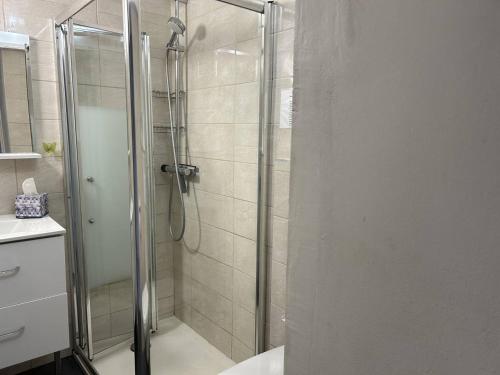 une douche avec une porte vitrée dans une salle de bain dans l'établissement Appartement climatisé 3 pièces avec terrasse, face à la plage, parking inclus - Bormes-les-Mimosas - FR-1-251-806, à Bormes-les-Mimosas