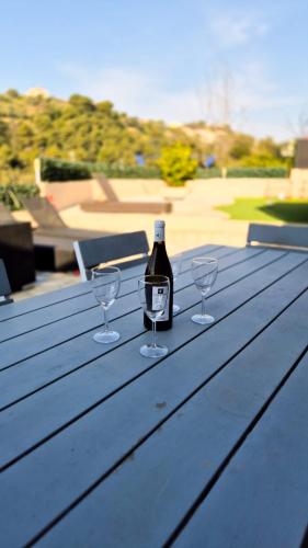 - une bouteille de vin et deux verres à vin sur une table de pique-nique dans l'établissement Maison avec grande terrasse sur Nice, à Nice