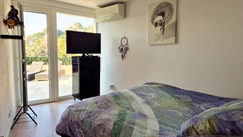 une chambre avec un lit et une télévision à écran plat dans l'établissement Maison avec grande terrasse sur Nice, à Nice