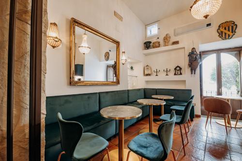 a restaurant with two tables and chairs and a mirror at Palazzo Giunta - Porta Marina Ortigia in Siracusa