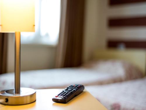 a remote control sitting on a table next to a lamp at Hotel San Giorgio in Tavazzano