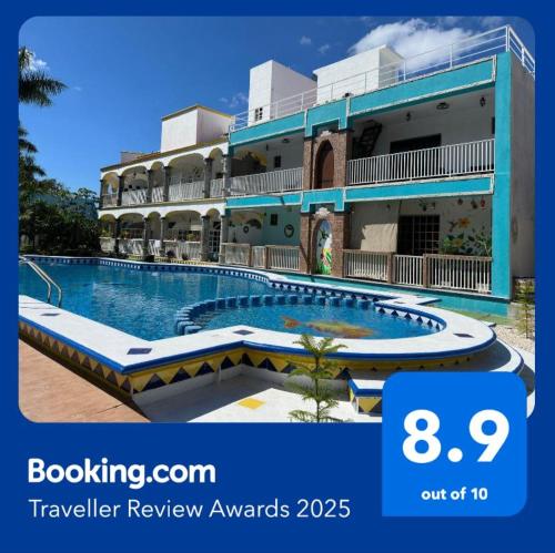 a hotel with a swimming pool in front of a building at Hacienda Cúpulas Blue Private Residence Club in Cozumel