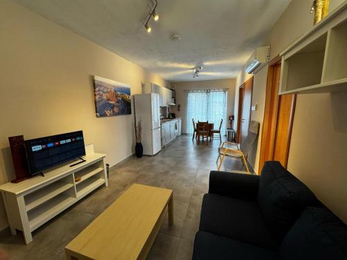 a living room with a couch and a tv at Sunny Retreat - Families, Couples & Digital Nomads in Is-Sellum