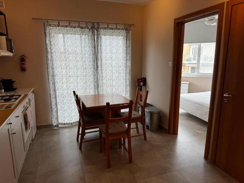 a kitchen with a table and chairs and a bedroom at Sunny Retreat - Families, Couples & Digital Nomads in Is-Sellum