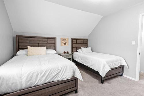 une chambre avec deux lits avec des draps blancs dans l'établissement Pinecone Escape - Close to Lake and Slopes, à Big Bear City