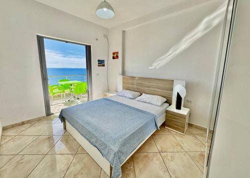 una camera da letto con un letto e vista sull'oceano di Corfu View Apartment a Sarandë