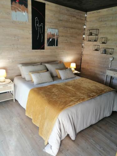 - une chambre avec un grand lit et des murs en bois dans l'établissement Suite climatisée jacuzzi privé, à Lachapelle-Auzac