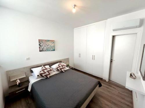 1 dormitorio con 1 cama y armarios blancos en Hive 365, en Livadhia