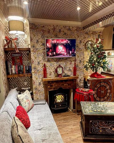 a living room with a christmas tree and a fireplace at Looking Glass Cottage in Brighton & Hove